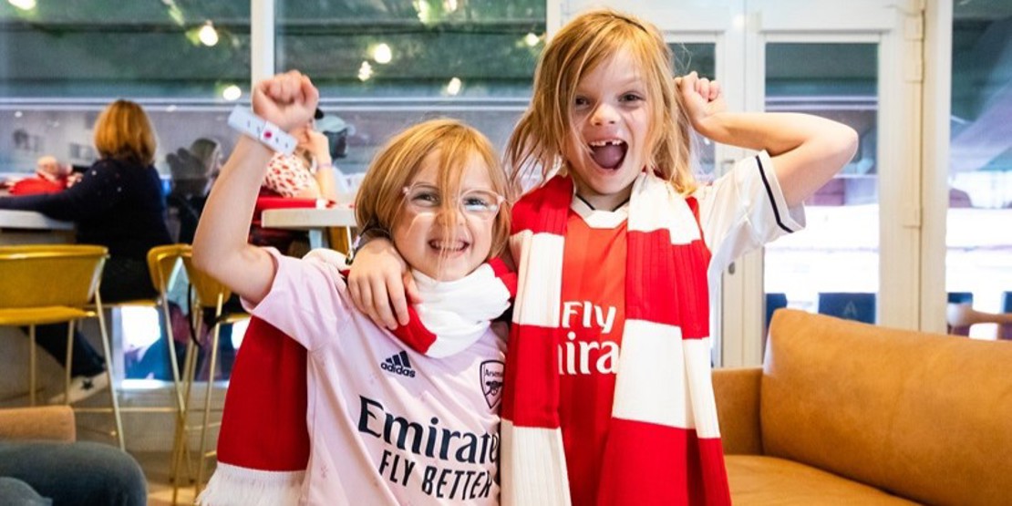 Two young Arsenal supporters at an Arsenal Women game at Emirates Stadium