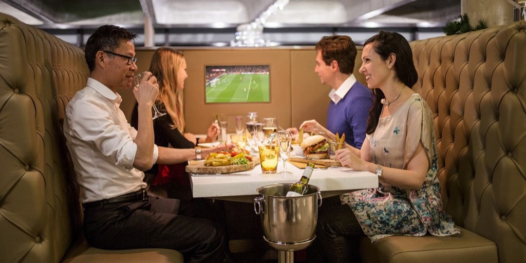 Group of supporters enjoying a meal in a booth in The Foundry