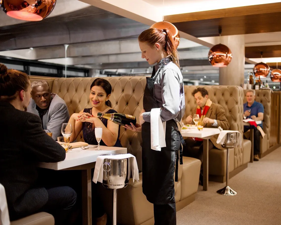 Supporters being served champagne in a booth in The Foundry
